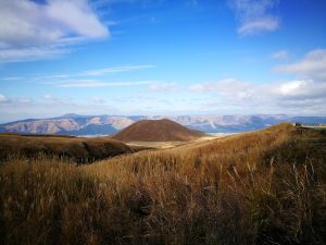 golden grasslands and small symmetrical volcano Komezuka autumn in Aso