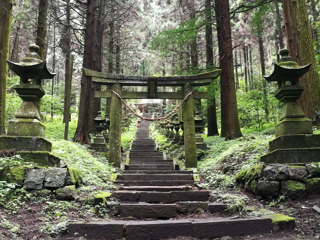 Kumamoto famous sightseeing spot Kamishikimi shrine in summer green stone lanterns and torii gate