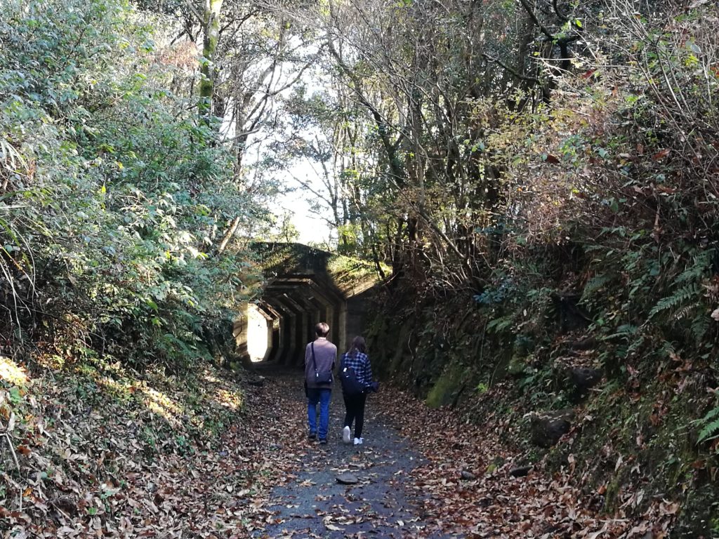 2 people walking along Hakkaku tunnel path