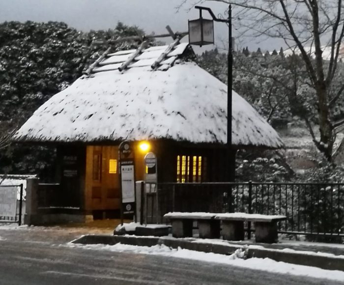beautiful thatched roof Japanese bus stop at dusk - kurokawa onsen tourur